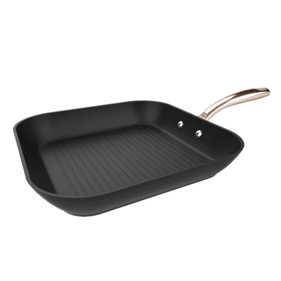 Vista superior del Grill Polka Fantasy 28 Grill Golden de Cecotec mostrando superficie estriada antiadherente y mango de acero inoxidable