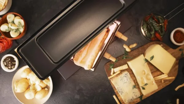 Imagen 5 Raclette Cheese&Grill 6000 Black de 600 W con función grill y acabados en acero inoxidable. Incluye parrilla antiadherente, termostato regulable y espátulas.